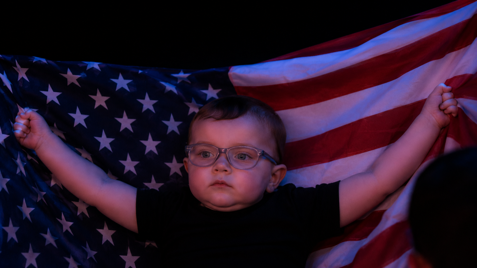 Baby attendee wrapped in an American flag during the celebration
